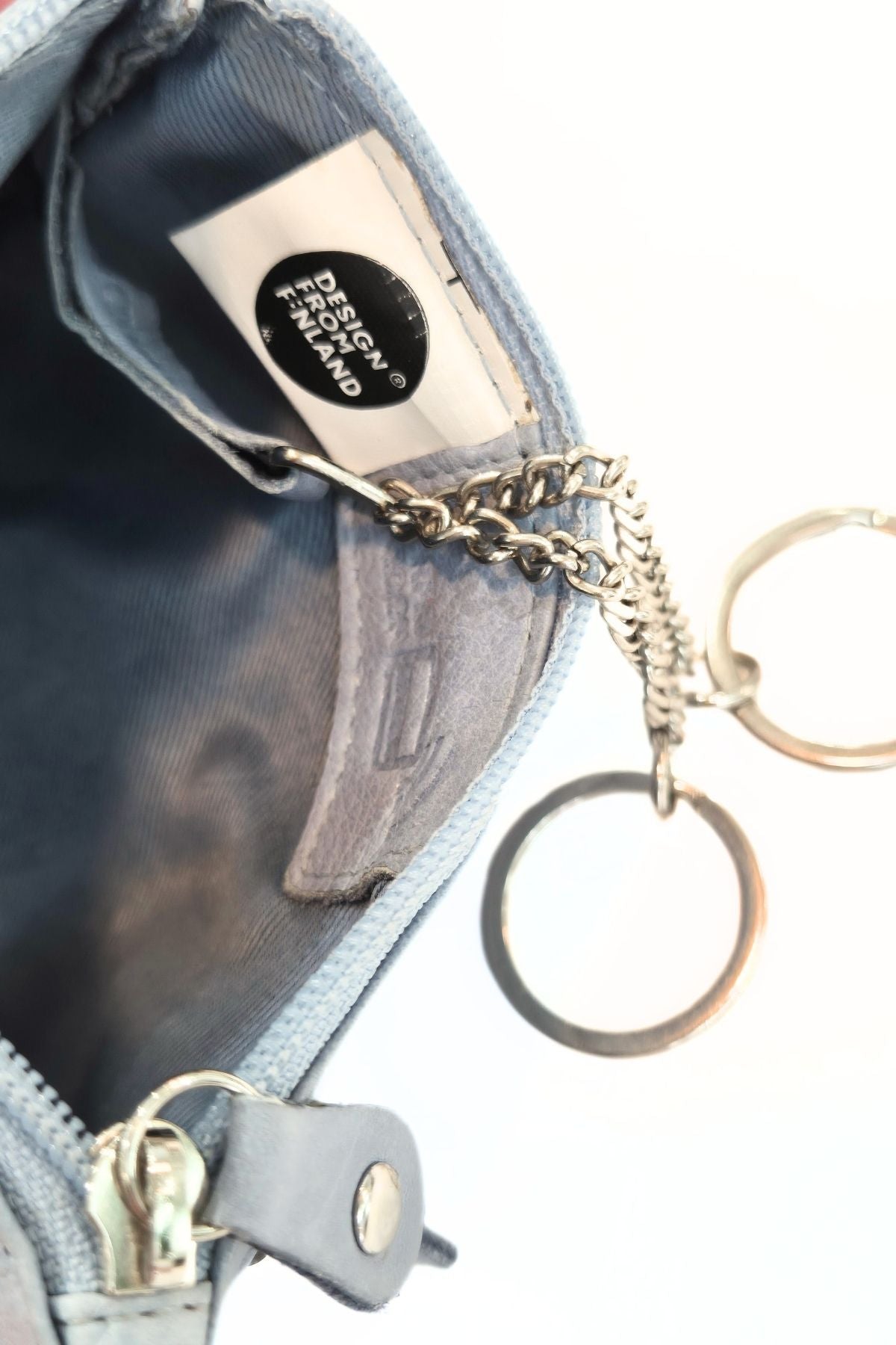 Lähikuva sinisen muumi kukkaron sisäpuolesta, Design from Finland merkki ja RFID suojaus.