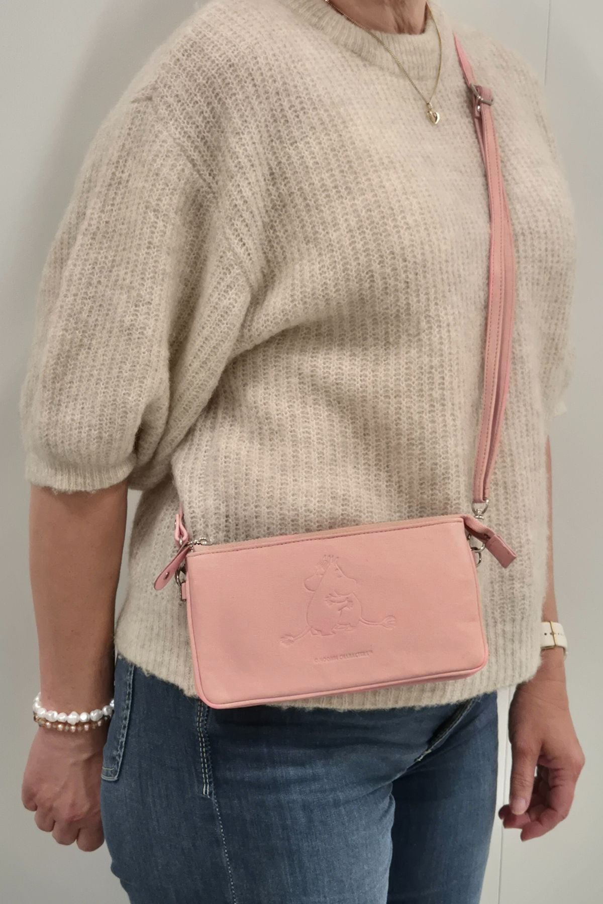 Roosa Muumi pikkulaukku käytössä, olkahihnallinen lompakko arjessa pikkulaukkuna