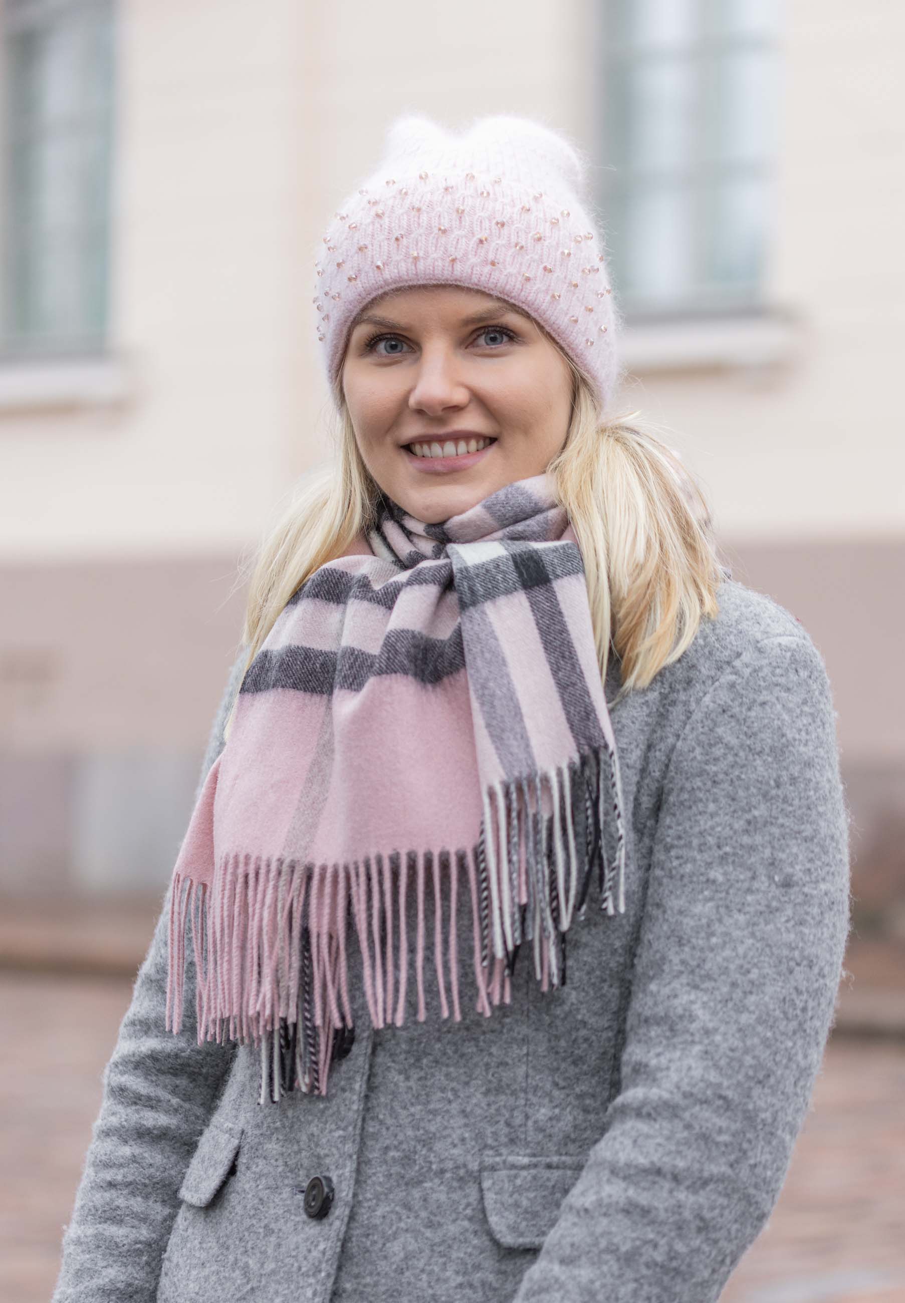 Mirella helmikoristeinen pipo vaaleanrosana käytössä naisella takin kanssa, pehmeä neulepipo talvisessa asussa
