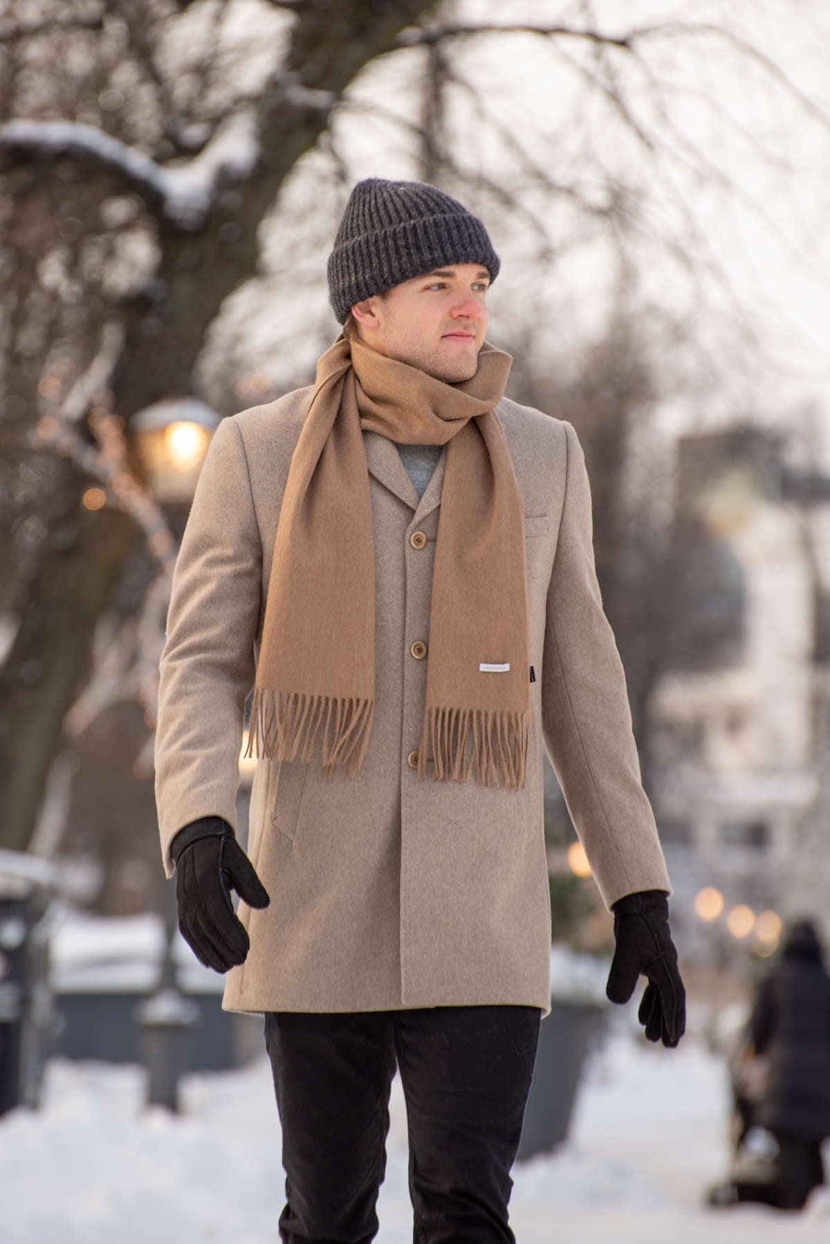 Ulkona kävelevä mies malli, jolla on villakaulahuivi sekä pipo.