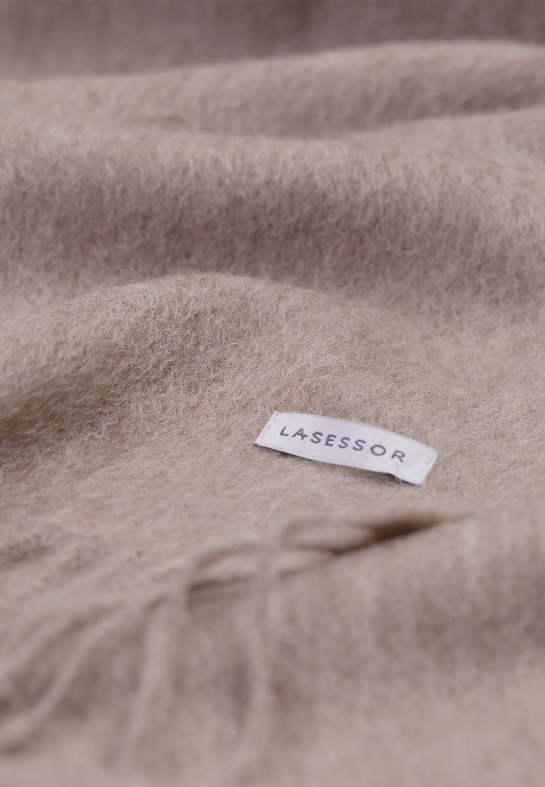 Lähikuva Huurre villakaulahuivi, jossa Lasessor logo, värissä nutria.