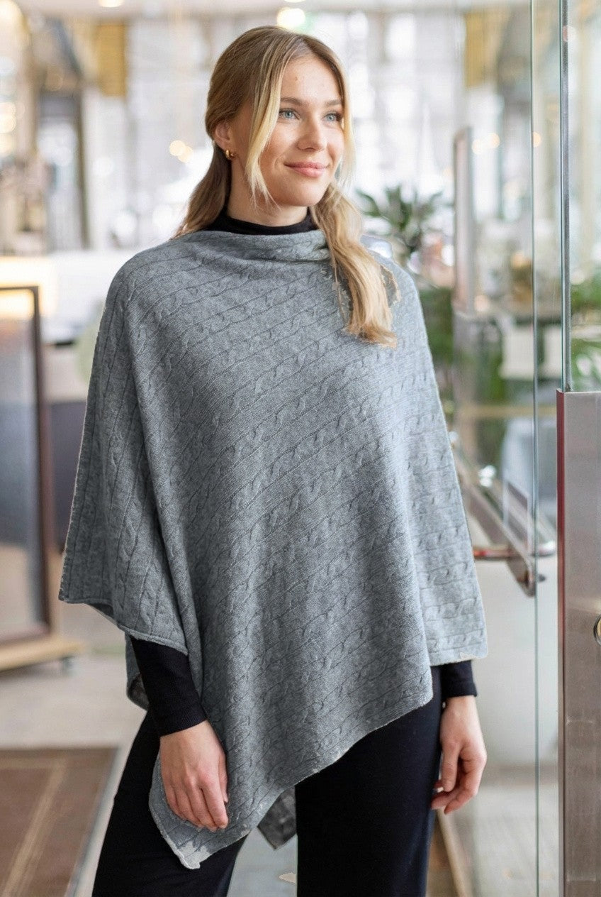 harmaa palmikkoneulottu poncho käytössä sisäpukeutumisessa, lämmin ja ajaton naisten asuste