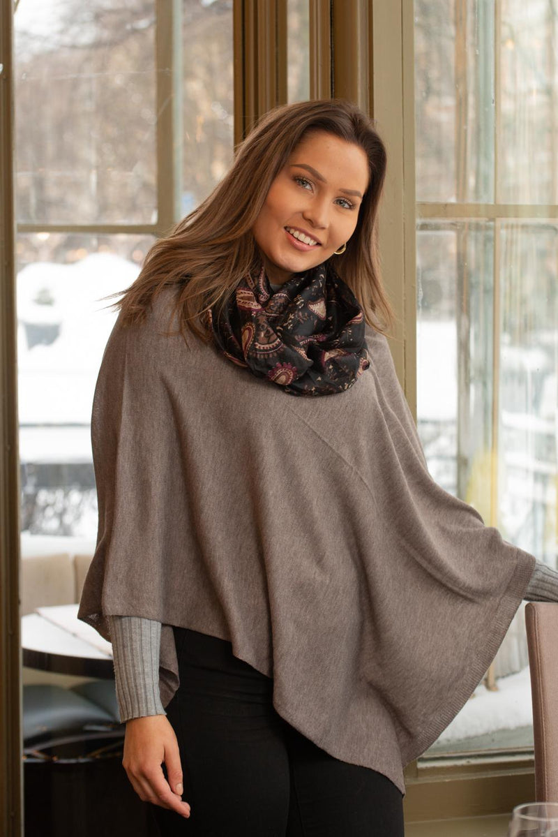 Image of model wearing Juolas Poncho in color nutria and other accessories